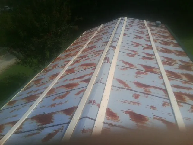 Rusted metal roof panels with new wood purlins before replacement — Storm Damage Roof Repair in Bassett by Roofing Brothers